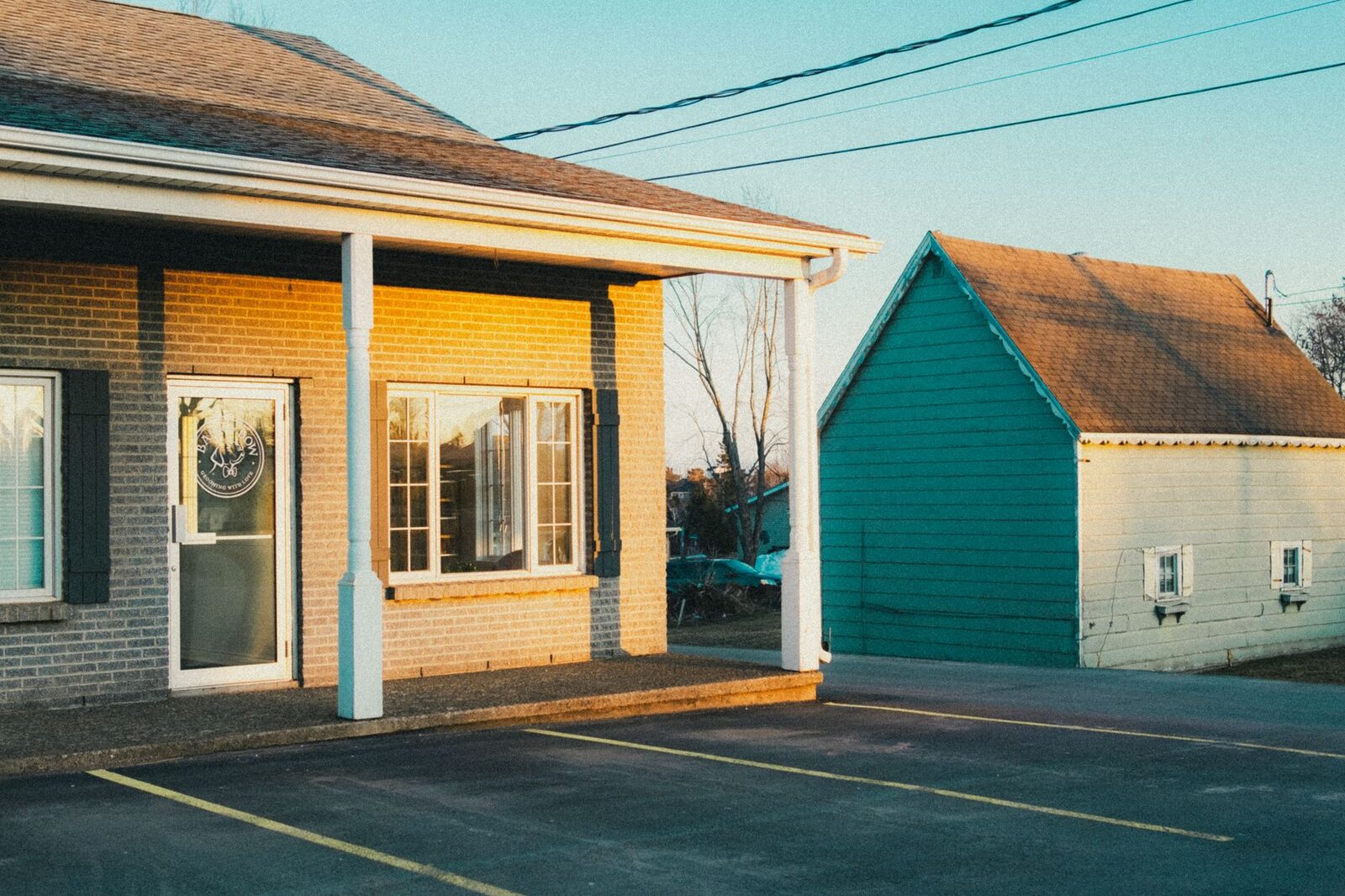 A serene image of suburban buildings and parking lot during golden hour.